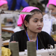 A Cambodian garment worker operates a sewing machine at a factory as they wait for welcoming visiting by Prime Minister Hun Sen at Phnom Penh Special Economic Zone in the outskirts of Phnom Penh, Cambodia, Wednesday, Aug. 23, 2017. Hun Sen on Wednesday began his plan to visit workers at factories in Cambodia.